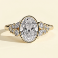 The Gemelle - Oval Cut Lab Grown Diamond Bezel Set Engagement Ring with Clustered Shoulder Accents