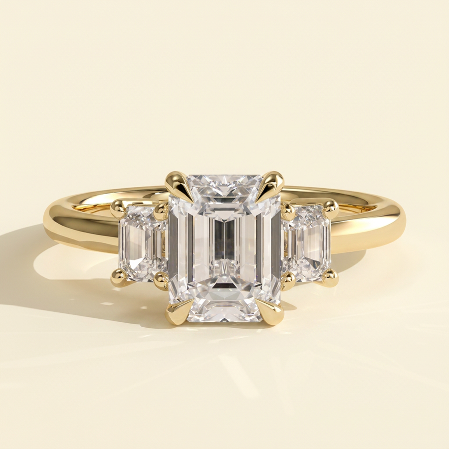 The Miriana - Emerald Cut Lab Grown Diamond Three Stone Engagement Ring with Matching Emerald Side Stones and Low Basket Setting - Yellow Gold